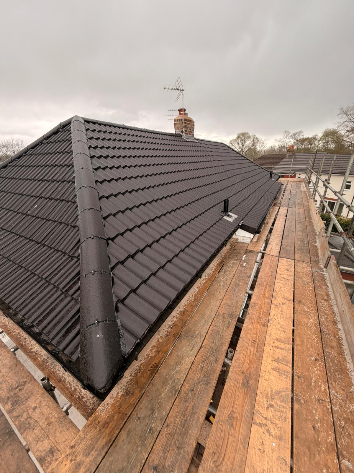 Completed hipped roof in dark grey tile
