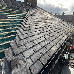 Slate tiles being installed on a pitched roof