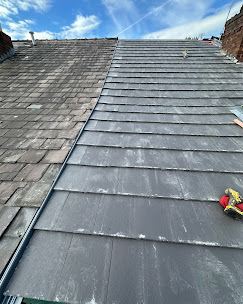 Re-roofed slate roof against a blue sky